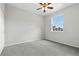 Bright bedroom with neutral carpet, ceiling fan, and large window providing natural light and neighborhood views at 8489 Canyon Rim Cir # 302, Englewood, CO 80112