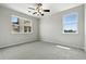 Bright bedroom with neutral carpet, ceiling fan, and large windows providing natural light and neighborhood views at 8489 Canyon Rim Cir # 302, Englewood, CO 80112