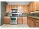 Spacious kitchen with stainless steel appliances, tile floor and wood cabinets at 8489 Canyon Rim Cir # 302, Englewood, CO 80112