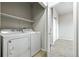 Washer and dryer in laundry area; shelving above with view to bedroom with carpet at 8489 Canyon Rim Cir # 302, Englewood, CO 80112