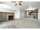 Open-concept living room with a fireplace and view into the kitchen area at 8489 Canyon Rim Cir # 302, Englewood, CO 80112