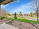 Scenic backyard view with lush grass, rock garden, and neighborhood street at 5781 S Union Ter, Littleton, CO 80127