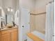 Bathroom featuring wooden vanity, granite countertop, stylish vessel sink, and tiled shower-tub combination at 5781 S Union Ter, Littleton, CO 80127