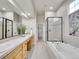 Large bathroom with double sinks, a walk-in shower, and a soaking tub at 5781 S Union Ter, Littleton, CO 80127