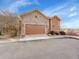 Home exterior showcasing the attached two-car garage with a stone facade and a paved driveway at 5781 S Union Ter, Littleton, CO 80127