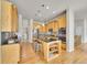 Open kitchen with a central island, stainless steel appliances, custom cabinets, and hardwood floors at 5781 S Union Ter, Littleton, CO 80127