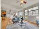 Open-concept living room with hardwood floors, neutral decor, and abundant natural light from large windows at 5781 S Union Ter, Littleton, CO 80127