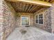 Covered outdoor patio with stone surround, sliding glass door, and large windows at 5781 S Union Ter, Littleton, CO 80127
