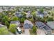 An aerial shot shows a blue house with a large driveway and manicured lawns at 16839 Trail View Cir, Parker, CO 80134