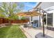 This backyard has a cozy patio with an umbrella, chairs, and an artificial lawn at 16839 Trail View Cir, Parker, CO 80134