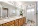 Bathroom featuring double sinks, wood cabinets, large mirrors and a separate toilet area at 16839 Trail View Cir, Parker, CO 80134
