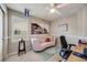 Bright office with a cute pink sofa, window, and large art piece at 16839 Trail View Cir, Parker, CO 80134