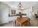 Bright open eat-in kitchen features white cabinets, stone backsplash, stainless steel appliances, and seating at 20137 E Prentice Pl, Centennial, CO 80015