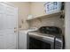 Well-lit laundry room featuring modern washer and dryer units and ample shelving for storage at 20137 E Prentice Pl, Centennial, CO 80015