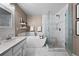 A serene bathroom features a soaking tub, a glass-enclosed shower, and a vanity with marble countertops at 5535 S Rome St, Aurora, CO 80015