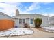 Gray house with stone chimney, wooden fence, and small landscaping at 12780 E Bethany Pl, Aurora, CO 80014