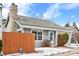 Gray house with stone chimney, wooden fence, and small landscaping at 12780 E Bethany Pl, Aurora, CO 80014