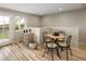 Charming dining area with light wood floors, a round table with four chairs, and a bright window with views of the exterior at 4972 Easley Rd, Golden, CO 80403
