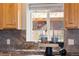 Beautiful kitchen view featuring granite countertops and wooden cabinetry looking out over the pasture at 4972 Easley Rd, Golden, CO 80403