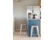 Kitchen island with seating, stainless steel refrigerator, and view of light wood floors at 4972 Easley Rd, Golden, CO 80403