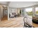 Bright living room with light wood floors, gray sofa, black coffee table, and French doors to a wooden deck with views of the yard at 4972 Easley Rd, Golden, CO 80403