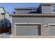 Attached two-car garage featuring brick accents and a gray door at 431 Courtfield Way, Castle Pines, CO 80108