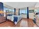 Bright bedroom boasts hardwood floors, multiple windows with blinds, and stylish dark blue curtains at 4385 Oakes Mill Ct, Castle Rock, CO 80109