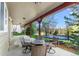 Covered back patio featuring an outdoor dining set and a view of the backyard and trees at 24005 High Meadow Dr, Golden, CO 80401