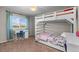 Light-filled bedroom with bunk bed and desk next to a large sunny window at 24005 High Meadow Dr, Golden, CO 80401