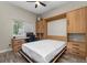 Bedroom features a built-in desk, Murphy bed with frame, storage cabinets and drawers, and neutral decor at 24005 High Meadow Dr, Golden, CO 80401