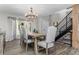 Elegant dining room with modern chandelier and a stylish staircase at 24005 High Meadow Dr, Golden, CO 80401