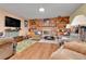 Cozy living room with a brick fireplace, built-in shelving, and wood laminate flooring at 12317 Fillmore Ct, Thornton, CO 80241