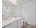 Bright bathroom featuring a double sink vanity with modern fixtures, a spacious mirror, and a shower with a tiled wall at 24777 E 40Th Ave, Aurora, CO 80019