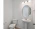 Stylish half-bathroom with a pedestal sink, an oval mirror, and modern fixtures at 24777 E 40Th Ave, Aurora, CO 80019