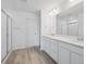 A modern bathroom featuring a double sink vanity with bright mirrors, white cabinets and a glass-enclosed shower at 24777 E 40Th Ave, Aurora, CO 80019