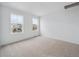 Sunlit bedroom showcasing neutral carpet, freshly painted white walls, and large windows with neighborhood views at 24777 E 40Th Ave, Aurora, CO 80019