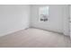 An empty bedroom bathed in natural light, showing neutral carpet, white walls, and a window view of the neighborhood at 24777 E 40Th Ave, Aurora, CO 80019
