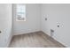 A practical laundry room with vinyl floors, equipped with utility connections and a bright window showcasing outside view at 24777 E 40Th Ave, Aurora, CO 80019