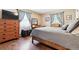 Cozy bedroom with hardwood floors, chest of drawers and natural light from large windows at 1808 Riverview Dr, Berthoud, CO 80513