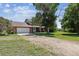 Two-story home with attached garage surrounded by mature trees and a spacious driveway at 1808 Riverview Dr, Berthoud, CO 80513