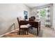 Bright home office with a classic wooden desk, comfortable chair, and natural light from the window at 1808 Riverview Dr, Berthoud, CO 80513