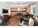 Inviting living room featuring a brick fireplace, wooden mantel, and comfortable leather furniture at 1808 Riverview Dr, Berthoud, CO 80513
