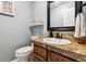 Charming powder room features wood vanity with solid surface counter and elegant fixtures at 1808 Riverview Dr, Berthoud, CO 80513
