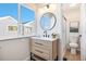 Stylish bathroom features a modern vanity, round mirror, and shower with glass doors at 186 S Nome St, Aurora, CO 80012