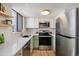 Well-lit kitchen features stainless steel appliances and light green lower cabinets at 186 S Nome St, Aurora, CO 80012