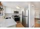 Bright kitchen featuring stainless steel appliances, light counters and green lower cabinets at 186 S Nome St, Aurora, CO 80012