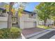 Gray townhouse exterior with a two-car garage and landscaping at 9200 E Cherry Creek South Dr # 10, Denver, CO 80231