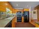 Well-lit kitchen with wood cabinets, stone backsplash, modern appliances, and dark countertops at 9200 E Cherry Creek South Dr # 10, Denver, CO 80231