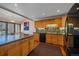 Bright kitchen featuring wood cabinets, stone backsplash, modern appliances, and an island with breakfast bar at 9200 E Cherry Creek South Dr # 10, Denver, CO 80231
