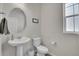 Clean powder room with pedestal sink, toilet and a large mirror at 27891 E 7Th Ave, Aurora, CO 80018